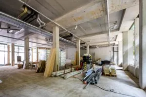 Binnenruimte van een gebouw aan de Karel du Jardinstraat in aanbouw met bouwmaterialen en onafgewerkte betonnen structuren.